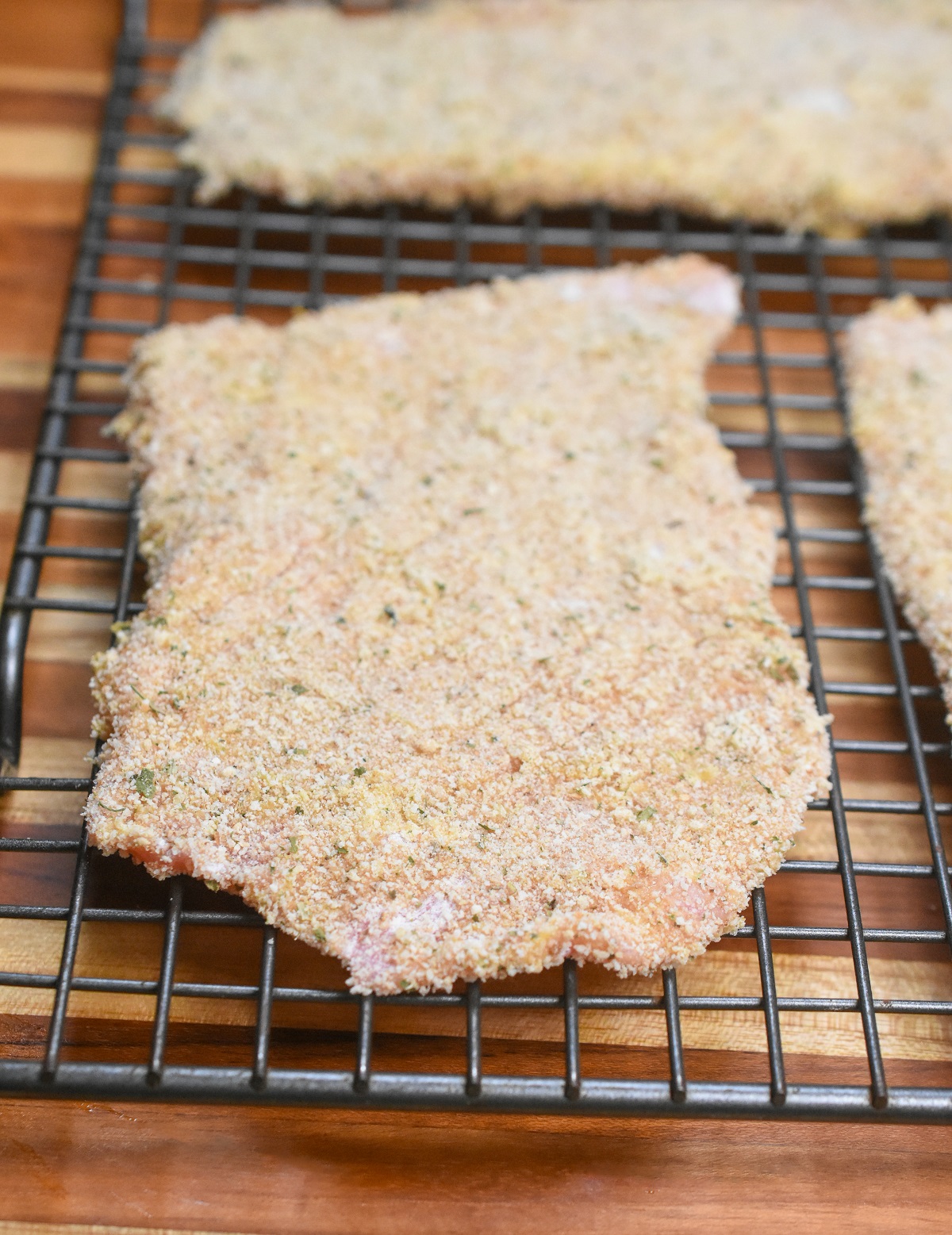 Weiner Schnitzel, shown breaded resting on a wire rack and ready to cook.
