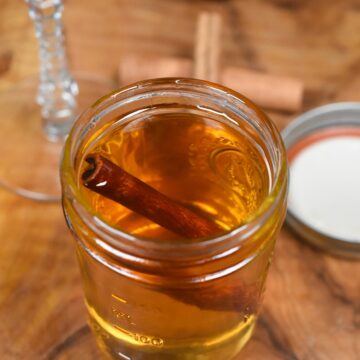 Cinnamon Syrup Recipe. Homemade Cinnamon Simple syrup in glass mason jar with cinnamon stick floating inside.