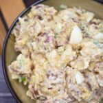 Nowl full of loaded potato salad. Creamy potato salad with bacon, scallions and egg