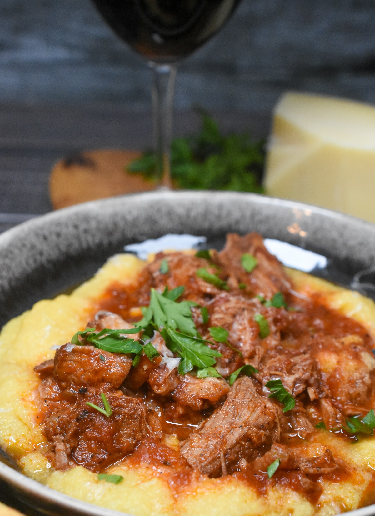 Ragout over pappardelle on a black plate garnished with basil 
