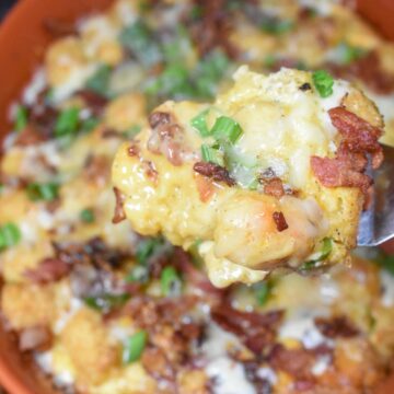 Tater Tot Breakfast Casserole Breakfast Casserole in an orange casserole baking dish topped with scallions, bacon and cheese
