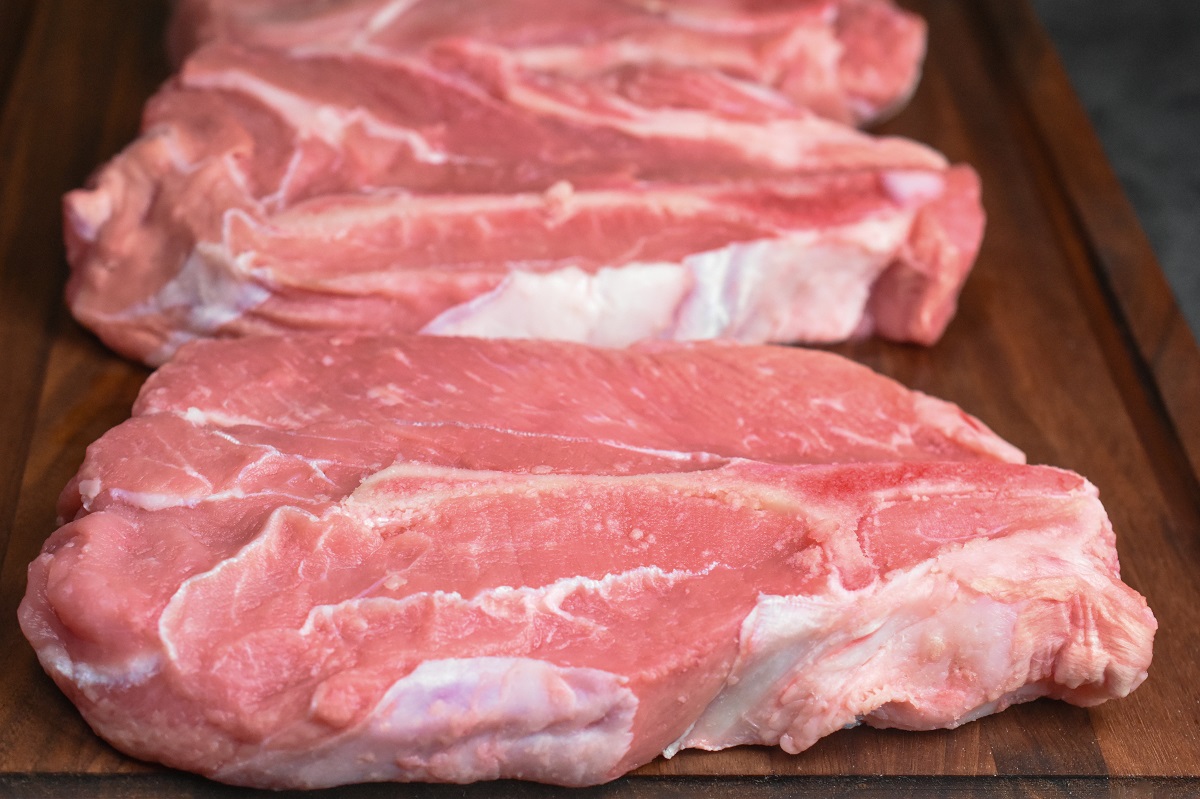 raw veal chuck chops on a wood cutting board