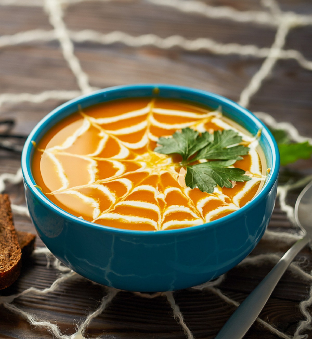 Bowl of Soup decorated with a spider web made of heavy cream for Halloween
