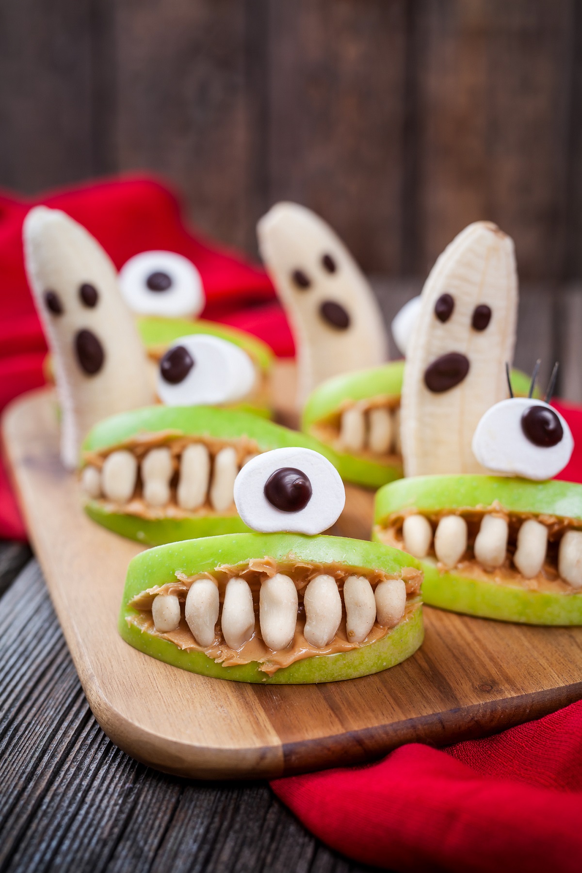 Halloween snacks for kids, apples made to look like a mouth and banana ghosts