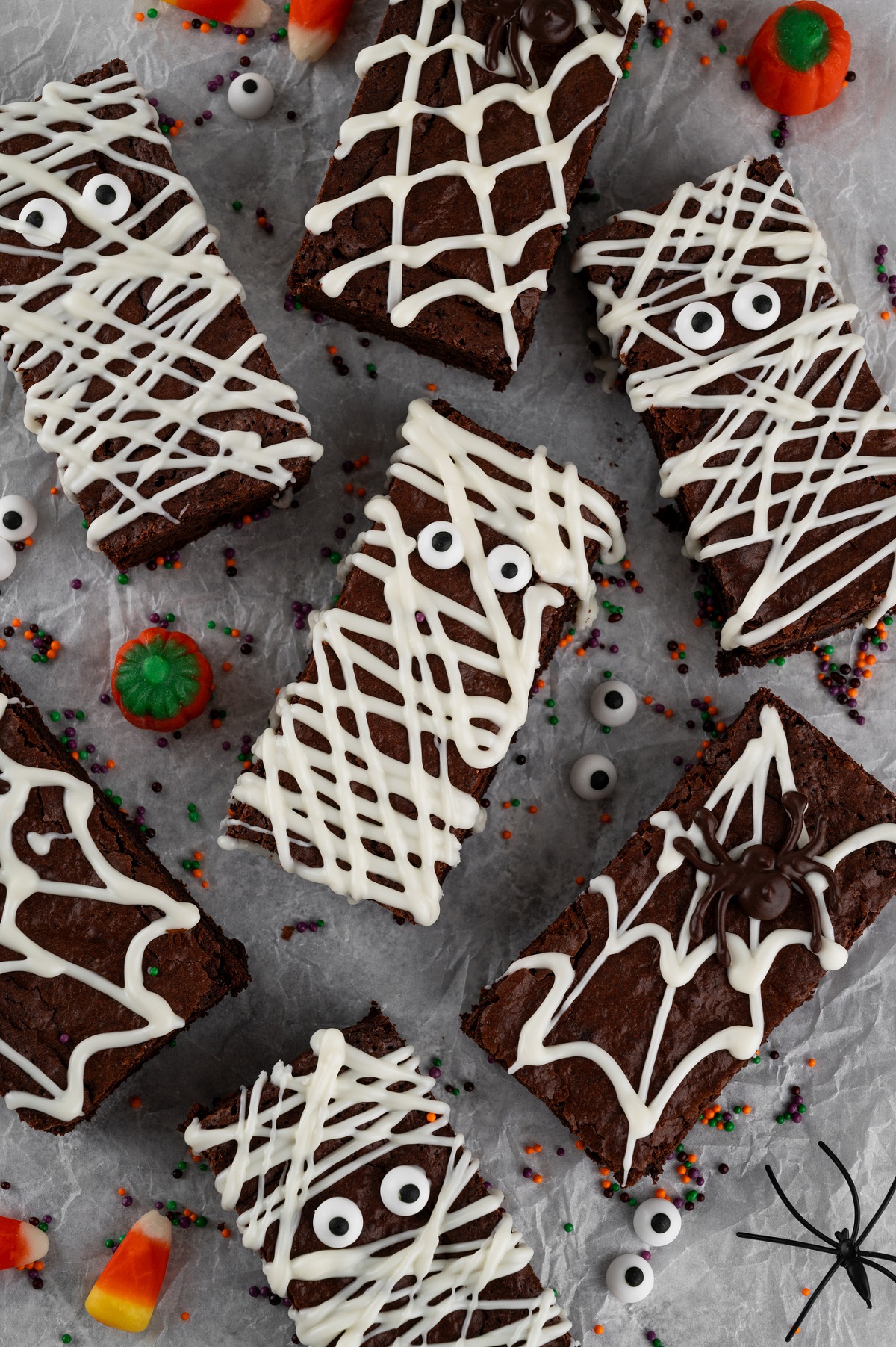 brownies drizzles with white chocolate to look like mummies with candy eyes
