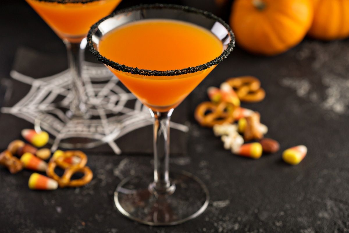 Orange drink in wince glass with black sugar rim. Halloween drink.